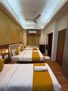 two beds in a hotel room with yellow and white at Hotel Sweet Inn in Mumbai +7 photos