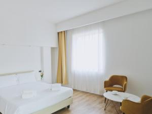 a bedroom with a bed and a chair and a table at Hotel Planet International in Arezzo