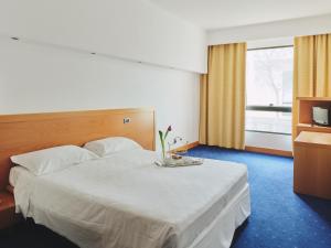 a hotel room with a large white bed and a window at Hotel Planet International in Arezzo +9 photos