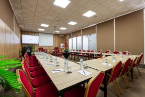 ein Konferenzraum mit einem langen Tisch und roten Stühlen in der Unterkunft Hotel Le Musée in Rabat