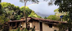 a rainbow over a house with a house at Hospedaria Quintal dos Sonhos in Vale do Capao