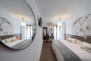 a hotel room with two beds and a mirror at Veracruz Boutique Puerta del Sol in Madrid