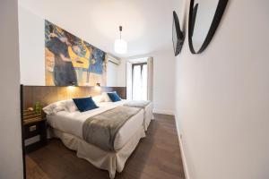 a bedroom with a bed and a painting on the wall at Veracruz Boutique Puerta del Sol in Madrid