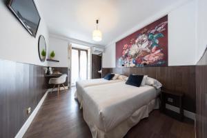 a hotel room with two beds and a painting on the wall at Veracruz Boutique Puerta del Sol in Madrid +78 photos