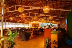 a restaurant with tables and chairs and chandeliers at Agonda Junction in Agonda