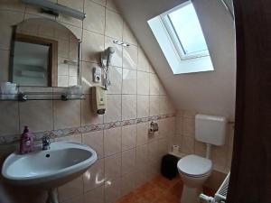 a bathroom with a sink and a toilet and a window at The Corner House Panzió in Tata +27 photos