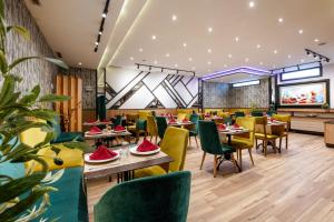 ein Restaurant mit Tischen und Stühlen und einem Flachbildfernseher in der Unterkunft Hotel Le Musée in Rabat