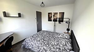 a bedroom with a bed and a desk with a lamp at FAA'mily Home, 3 bedrooms, meublé de tourisme 4 étoiles in Offemont