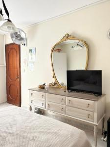 a bedroom with a dresser with a mirror and a tv at La Casa del Sole in Corleone