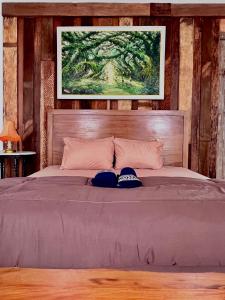 a bedroom with a bed with two hats on it at PaddyView Hostel in Banyuwangi