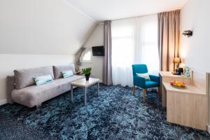 a living room with a couch and a table at Hotel Eureka in Sopot