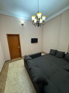 a large bed in a room with a couch at Jassehs Apartments in Brusubi