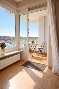 a living room with a window seat and a table with a view at Strandhafer-Balkon mit Meerblick- 2 Min zum Strand in Schausende