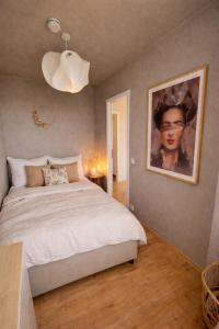 a bedroom with a bed and a painting on the wall at Strandhafer-Balkon mit Meerblick- 2 Min zum Strand in Schausende