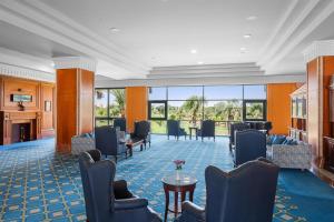 a lobby with chairs and a table and windows at Hilton Pyramids Golf in 6th Of October