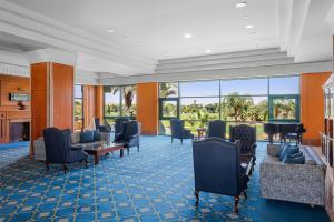 a hotel lobby with chairs and tables and windows at Hilton Pyramids Golf in 6th Of October