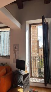 a living room with a computer on a desk and a window at Arcangelo SUITE in Assisi