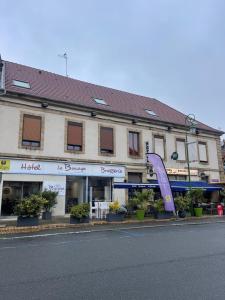 a building with a large purple sculpture in front of it at Logis Hôtel Le Bocage in Montmarault