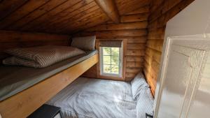 a room in a log cabin with a bed and a window at Cabin Retreat in Trawsfynydd