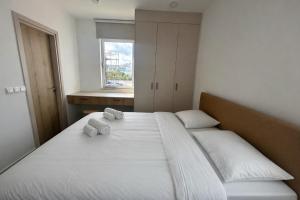 a bedroom with a bed with two pillows and a window at Terra Rossa Residences in Paralimni