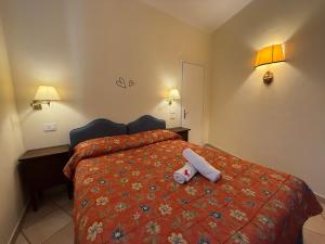 a hotel room with a bed with a towel on it at Villa Le Camelie Siena in Siena