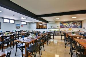 a dining room with wooden tables and chairs at Flat completo e confortável in Cuiabá