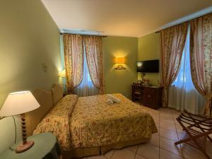a hotel room with a bed and a television at Villa Le Camelie Siena in Siena