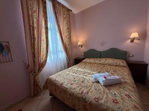 a bedroom with a bed with two towels on it at Villa Le Camelie Siena in Siena