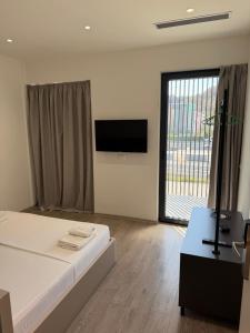 a bedroom with a bed and a flat screen tv at Leon Hotel in Kashari
