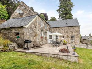 an exterior view of a stone house with a patio at 4 Bed in Pitlochry oc-ca274 in Foss