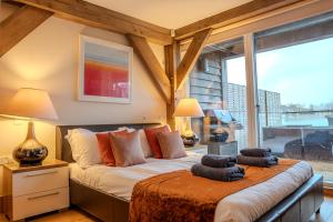 a bedroom with a bed with two pillows on it at Lakeside Cotswolds Retreat with Private Hot Tub set on Lower Mill Estate in Somerford Keynes +39 photos