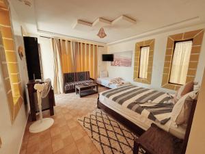 a bedroom with a bed and a living room at RyadIbou in Essaouira