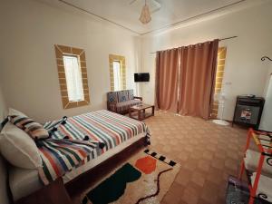 a bedroom with a bed and a living room at RyadIbou in Essaouira