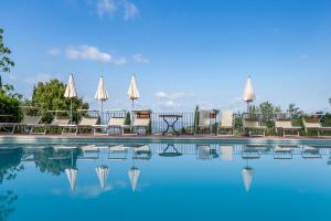 a swimming pool with chairs and tables and umbrellas at Podere Mezzastrada - Place of Charme in Fiano