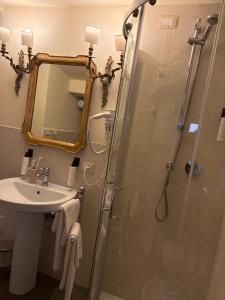 a bathroom with a shower and a sink and a mirror at Palazzo Lari Sarzana - Historic Boutique Rooms in Sarzana +64 photos