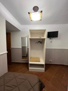 a room with a bed and a refrigerator and a light at Hostal Hueso in Trujillo