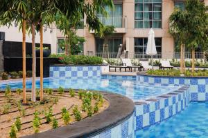 a swimming pool with palm trees and a building at Romantic hideaway with Burj view in Dubai
