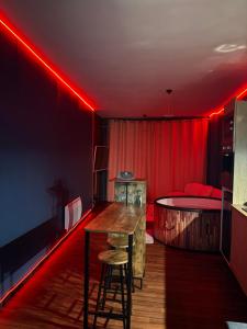 a room with a bed and a table and red lights at L'Envers SPA - Suite Romantique Metz Centre in Metz
