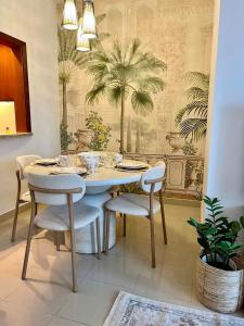 a dining room with a table and chairs with a palm wallpaper at Romantic hideaway with Burj view in Dubai