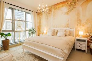 a bedroom with a large white bed and a chandelier at Romantic hideaway with Burj view in Dubai