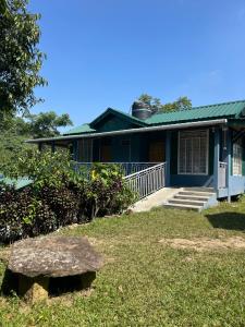 a blue house with a stone bench in front of it at Verde Guest House in Shillong
