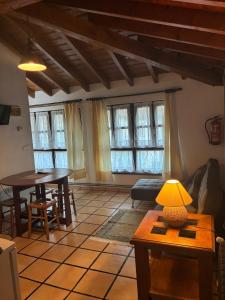 a living room with a table and chairs and windows at rincón de covadonga in Caño