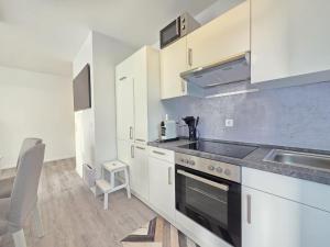 a kitchen with a sink and a stove top oven at Ferienwohnung NordTroll in Norden
