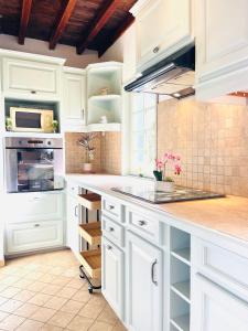 a kitchen with white cabinets and a counter top at La Longère au Fil des Saisons in Favières +20 photos