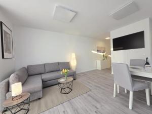 a living room with a couch and a table at Ferienwohnung NordTroll in Norden