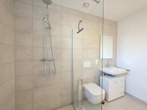 a bathroom with a shower and a toilet and a sink at Ferienwohnung NordTroll in Norden +32 photos
