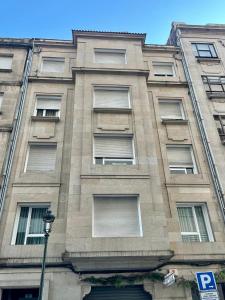 a tall building with many windows and a street light at Apartamento Cúrcuma - Vigo Centro in Vigo