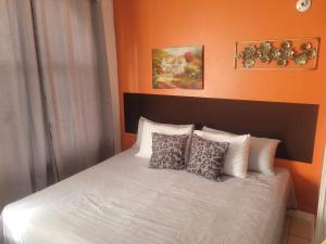 a bed with four pillows on top of it at Mar Paraiso in Ocho Rios