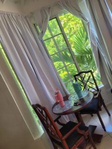 a table and two chairs in front of a window at Mar Paraiso in Ocho Rios