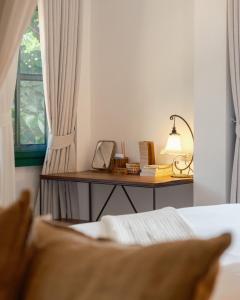 a bedroom with a desk with a lamp and a window at Big Tree Boutique Hotel in Ko Tao +77 photos